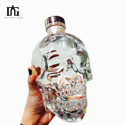Botella de licor transparente de 700 ml de capacidad con forma de cráneo grabado y tipo de sellado CORK